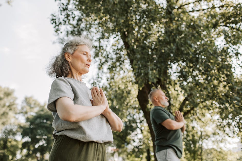 Senior couple meditating outdoors in nature during the day, promoting health