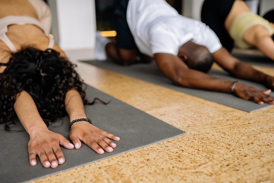A diverse group of people stretching on yoga mats in a studio, focusing on fitness and relaxation