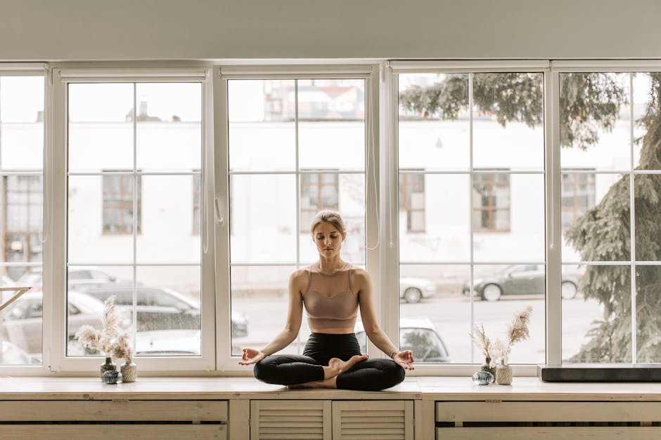 Calm woman practicing meditation on a windowsill indoors, embracing mindfulness and relaxation